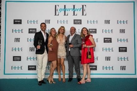 Grupo de personas posando delante de una paredDescripci�n generada autom�ticamente con confianza media