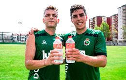 Los jugadores Íñigo Vicente (izquierda), centrocampista, e Íñigo Sainz (derecha), capitán del equipo, posan con Agua de Solares.